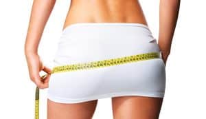 Person measuring their waist with a tape measure