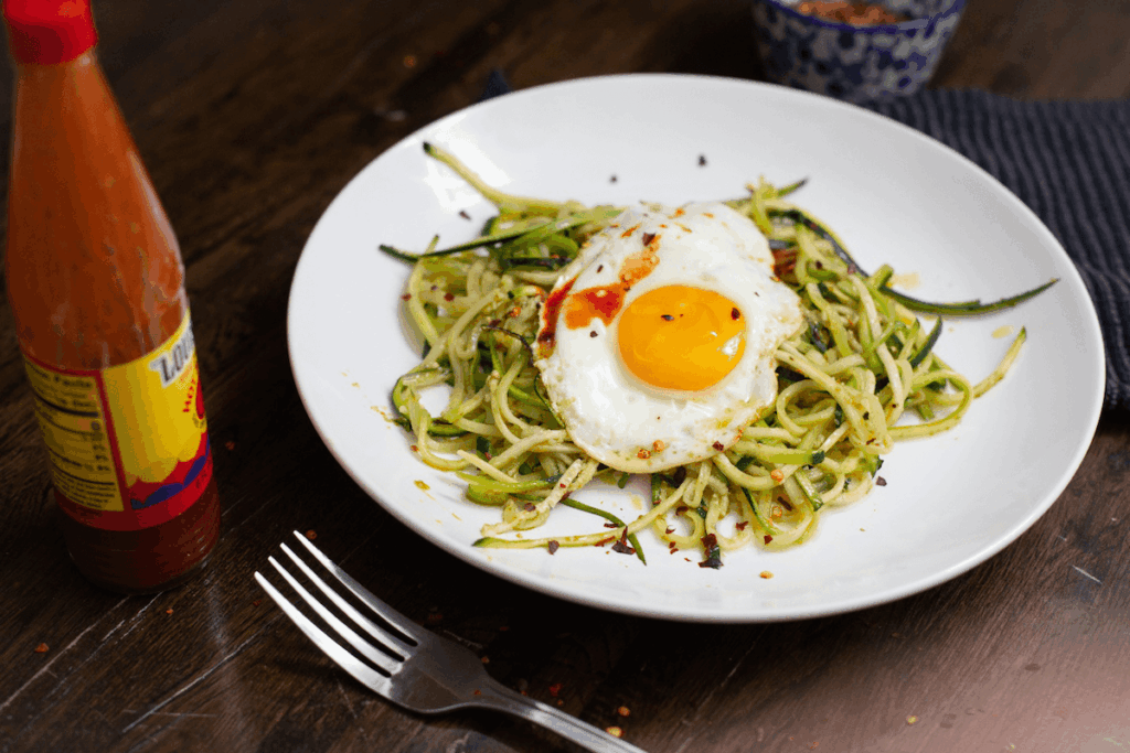 Pesto zucchini noodles topped with a fried egg