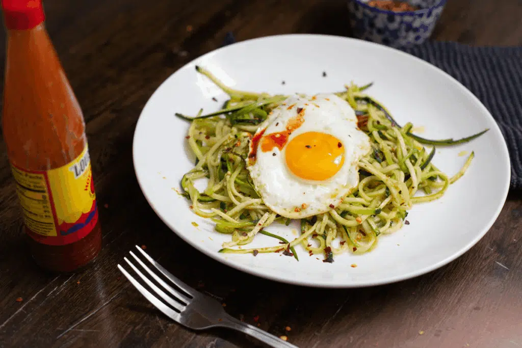 Pesto zucchini noodles topped with a fried egg